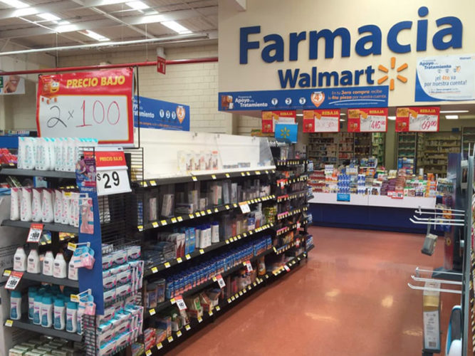 blue farmacia walmart sign above pharmacy counter with shelves of stock in front