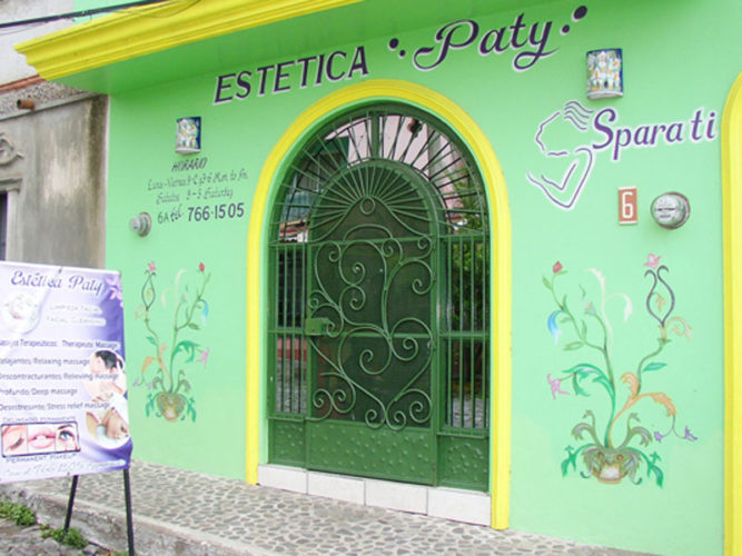streetview of estetica paty with green walls colourful painted scrolls contact information sandwich board with offers out front
