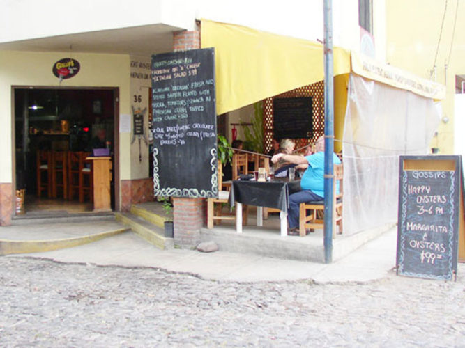 Gossips, an Ajijic restaurant on the main road in ajijic showing large chaulkboard menu beside the outdoor dining area.