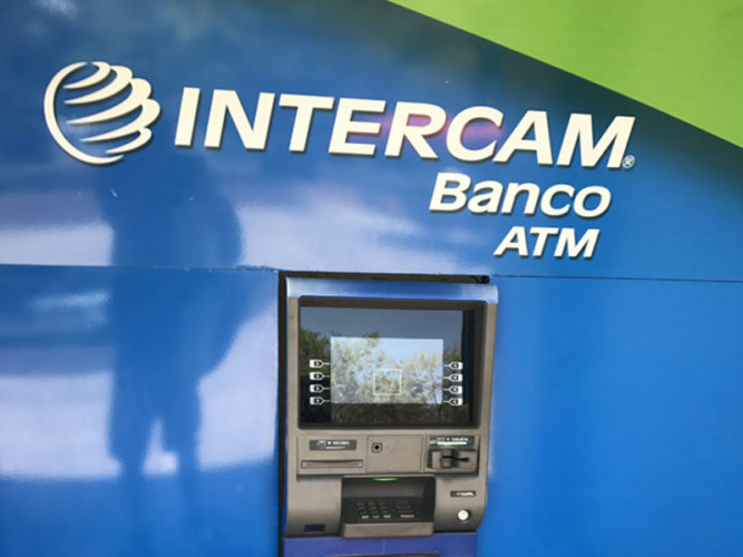 intercam banco atm inset on a bright blue wall with white corporate lettering and logo above it