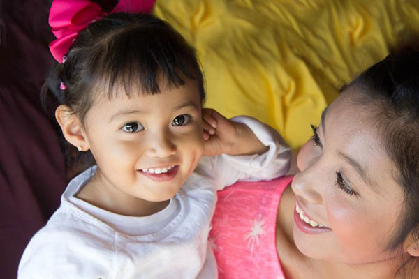 Mexican girl and her mother happily waiting in line for their dispensa.