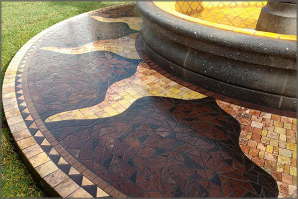 Mosaic stone border around a cantera garden fountain depicting the suns flames by Artist Federico Ramos.