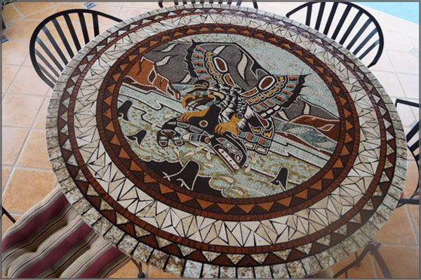 Mosaic table top of eagle with a whale in it's claws flying above the ocean by Artist Federico Ramos.