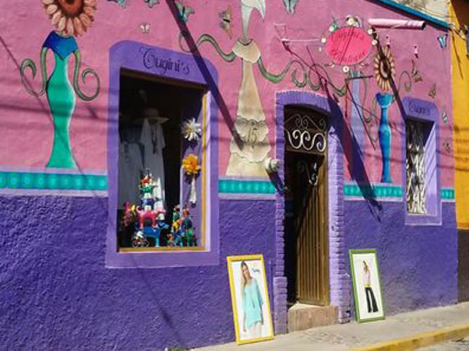 Pink and purple walls with whimsical drawings on wall of Cugini's Boutique in Ajijic