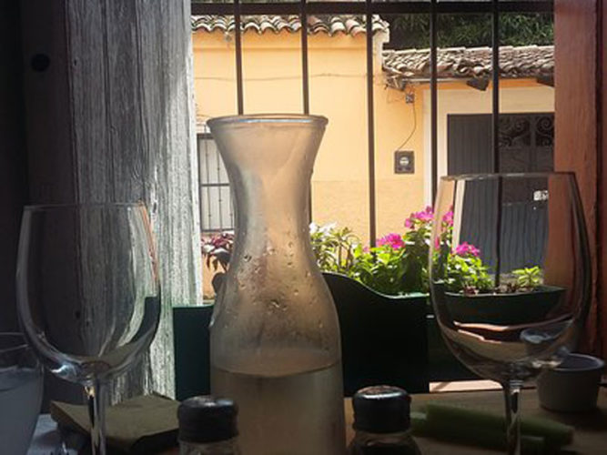 Two wine glasses and frosty carafe on the table at Ajijic restaurant Pasta Trenta.