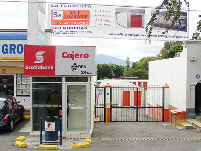 Scotia Bank atm behind glass enclosure beside la floresta self storage sign and entrance