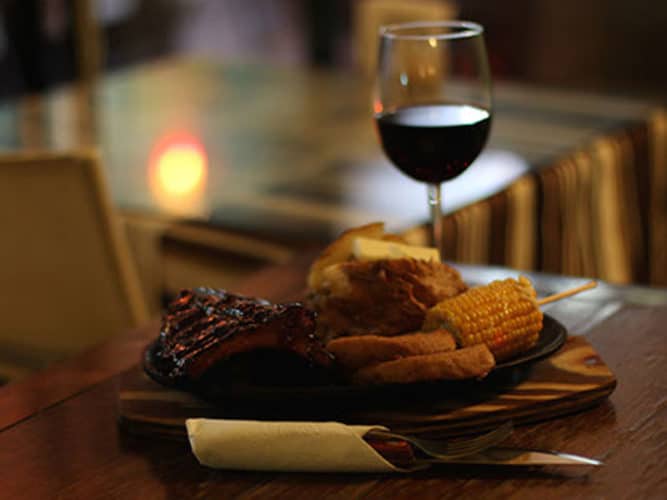 Plate of food and glass of wine at Bruno's Steakhouse, one of the many Ajijic Restaurants serving grilled meat.